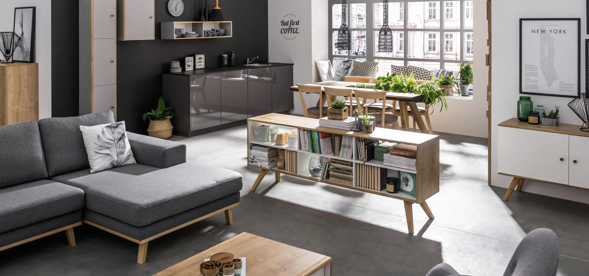 Biało-szary salon z drewnianymi meblami, ciemnoszarą sofą i szarą podłogą